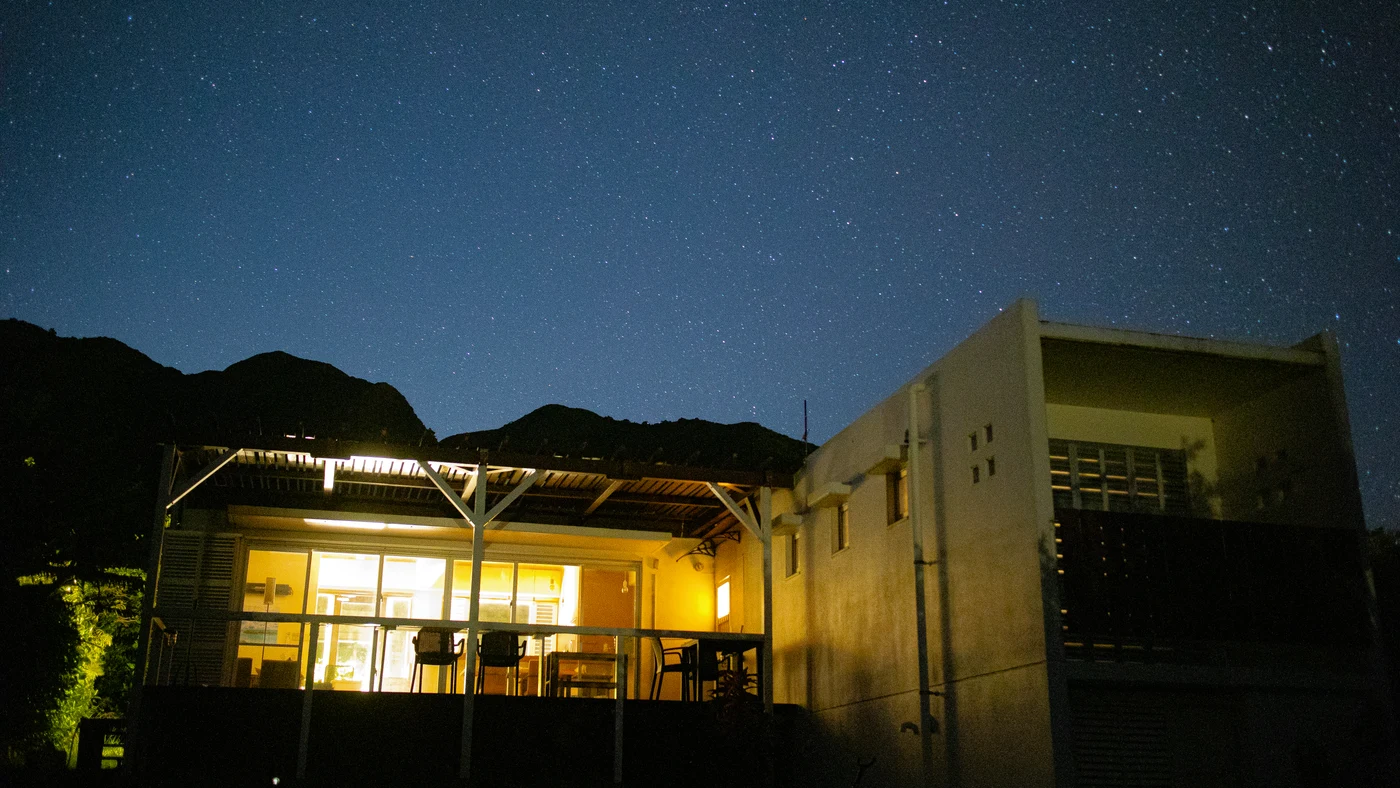 星空の下に灯りがともる建物